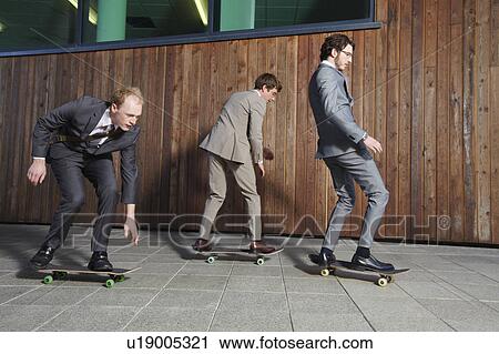 Businessmen riding skateboards View Large Photo Image Stock Image - Businessmen riding skateboards. Fotosearch