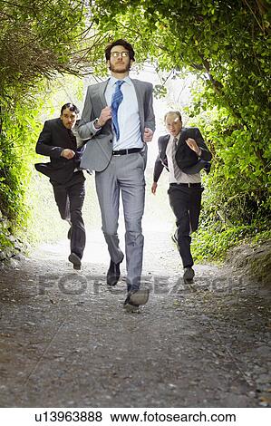 Businessmen running on rural road View Large Photo Image Stock Photo - Businessmen running on rural road. Fotosearch