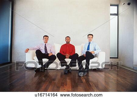 Picture - Businessmen sitting on couch in office. Fotosearch