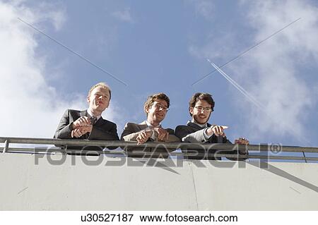 Businessmen standing on walkway View Large Photo Image Stock Photo - Businessmen standing on walkway. Fotosearch