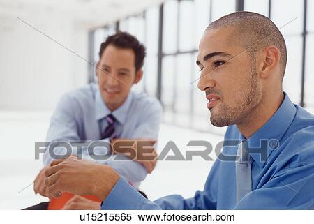 Stock Photography - Businessmen talking at desk. Fotosearch