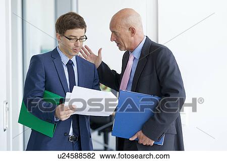 Businessmen talking in office View Large Photo Image Stock Image - Businessmen talking in office. Fotosearch
