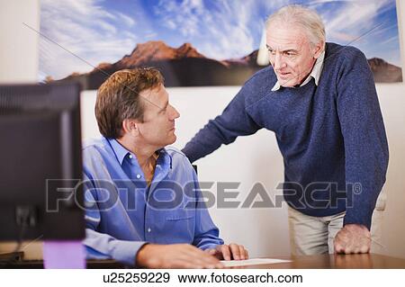 Stock Photo - Businessmen talking in office. Fotosearch