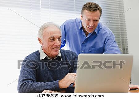 Businessmen using laptop in office View Large Photo Image Stock Photo - Businessmen using laptop in office. Fotosearch