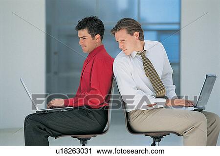 Businessmen using laptops in office View Large Photo Image Stock Image - Businessmen using laptops in office. Fotosearch