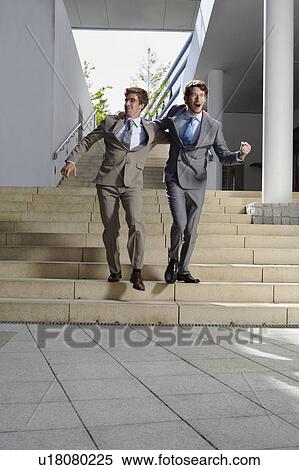 Businessmen walking arm-in-arm on steps View Large Photo Image Stock Photography - Businessmen walking arm-in-arm on steps. Fotosearch