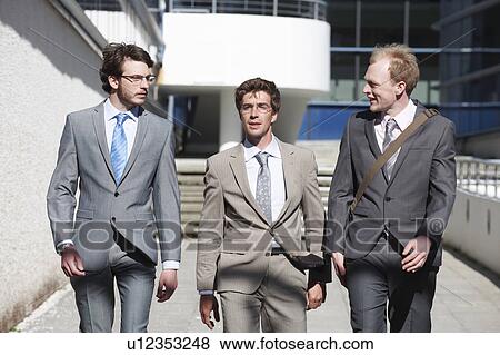 Stock Photo - Businessmen walking in courtyard. Fotosearch