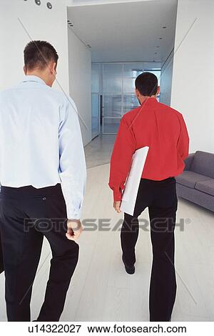 Businessmen walking in office View Large Photo Image Stock Photo - Businessmen walking in office. Fotosearch