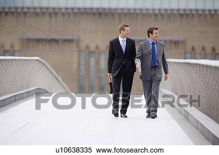 Businessmen walking on bridge together View Large Photo Image Stock Photography - Businessmen walking on bridge together. Fotosearch