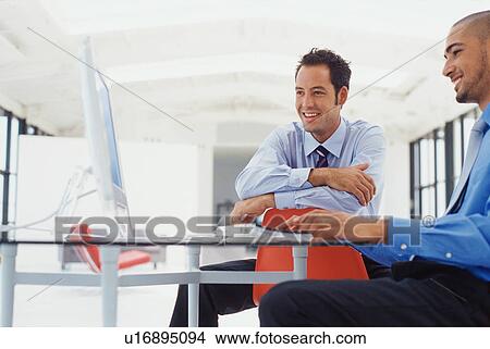 Picture - Businessmen working on computer. Fotosearch