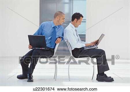 Businessmen working on laptops in office View Large Photo Image Picture - Businessmen working on laptops in office. Fotosearch