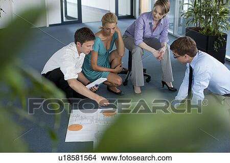 Businesspeople examining work in office View Large Photo Image Picture - Businesspeople examining work in office. Fotosearch