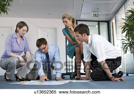 Businesspeople examining work in office View Large Photo Image Stock Photography - Businesspeople examining work in office. Fotosearch