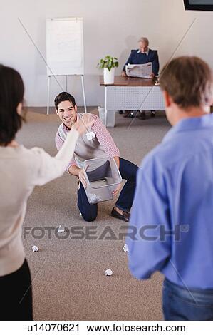 Stock Image - Businesswoman aiming trash into can. Fotosearch
