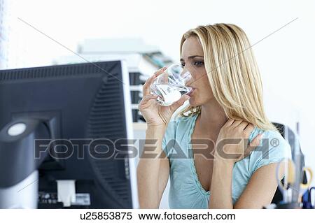 Businesswoman drinking water at desk View Large Photo Image Stock Photography - Businesswoman drinking water at desk. Fotosearch