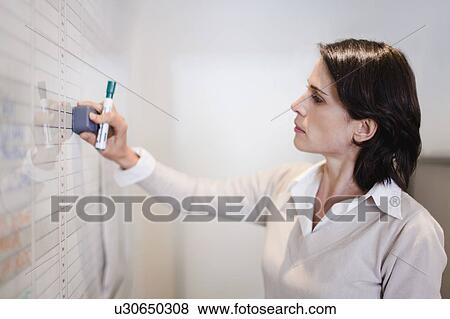 Businesswoman erasing whiteboard View Large Photo Image Stock Photo - Businesswoman erasing whiteboard. Fotosearch