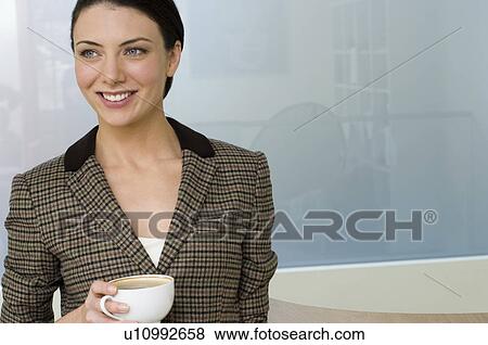 Stock Photo - Businesswoman holding coffee cup. Fotosearch