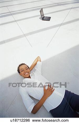 Businesswoman laying on floor View Large Photo Image Stock Photograph - Businesswoman laying on floor. Fotosearch
