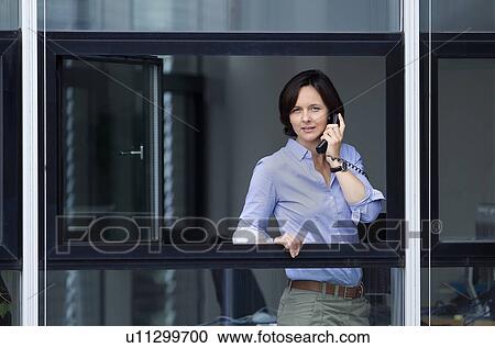 Businesswoman looking out office window View Large Photo Image Stock Image - Businesswoman looking out office window. Fotosearch