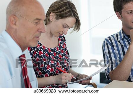 Stock Photo - Businesswoman making notes in conference. Fotosearch