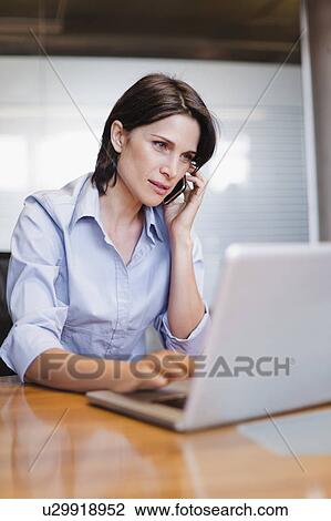 Businesswoman on cell phone and laptop View Large Photo Image Stock Image - Businesswoman on cell phone and laptop. Fotosearch