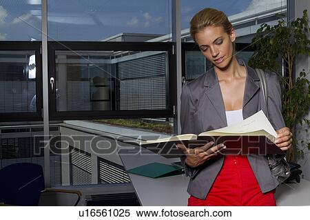 Businesswoman reading book in office View Large Photo Image Stock Photography - Businesswoman reading book in office. Fotosearch