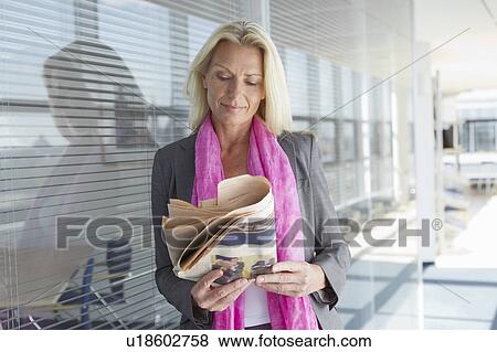 Stock Photo - Businesswoman reading newspaper. Fotosearch