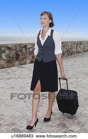 Businesswoman rolling luggage View Large Photo Image Stock Image - Businesswoman rolling luggage. Fotosearch