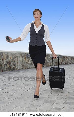 Businesswoman running with luggage View Large Photo Image Stock Image - Businesswoman running with luggage. Fotosearch