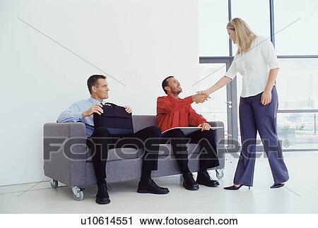 Stock Image - Businesswoman shaking colleague’s hand. Fotosearch