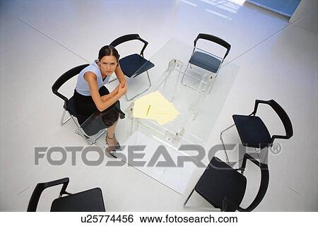 Businesswoman sitting at desk in office View Large Photo Image Stock Photograph - Businesswoman sitting at desk in office. Fotosearch
