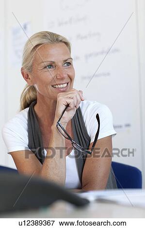 Businesswoman sitting at desk View Large Photo Image Stock Photo - Businesswoman sitting at desk. Fotosearch