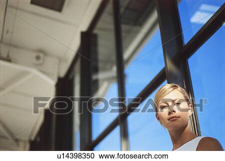 Stock Image - Businesswoman sitting in front of window. Fotosearch