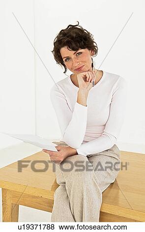 Businesswoman sitting on table View Large Photo Image Stock Photo - Businesswoman sitting on table. Fotosearch