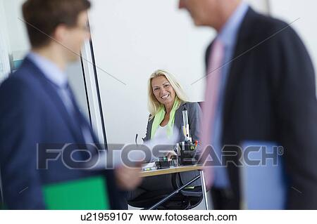 Businesswoman smiling at desk in office View Large Photo Image Stock Photo - Businesswoman smiling at desk in office. Fotosearch