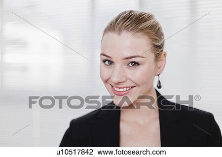 Stock Image - Businesswoman smiling in office. Fotosearch