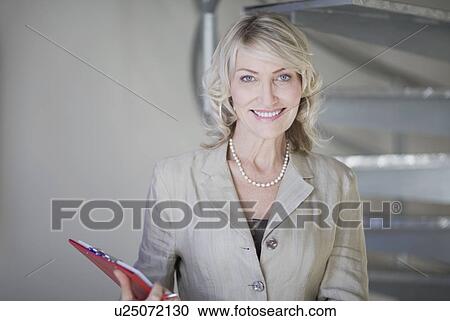 Businesswoman smiling in office View Large Photo Image Stock Image - Businesswoman smiling in office. Fotosearch