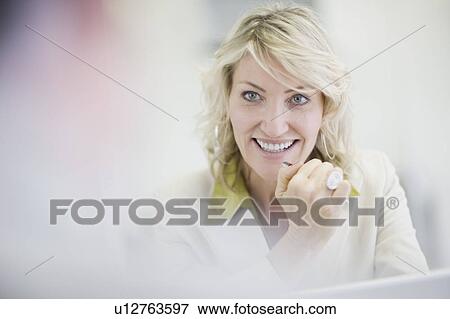 Stock Photo - Businesswoman smiling in office. Fotosearch