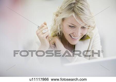 Stock Photograph - Businesswoman smiling in office. Fotosearch