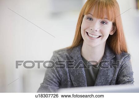 Businesswoman smiling in office View Large Photo Image Stock Photograph - Businesswoman smiling in office. Fotosearch