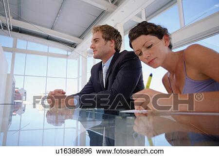 Stock Photograph - Businesswoman taking notes in meeting. Fotosearch