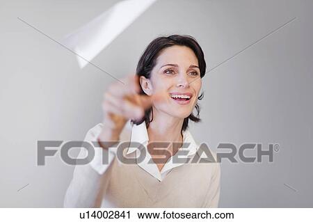 Businesswoman throwing paper airplane View Large Photo Image Stock Image - Businesswoman throwing paper airplane. Fotosearch