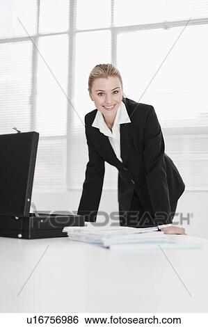 Businesswoman unpacking briefcase View Large Photo Image Stock Photograph - Businesswoman unpacking briefcase. Fotosearch