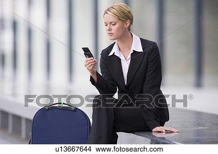Picture - Businesswoman using cell phone outdoors. Fotosearch