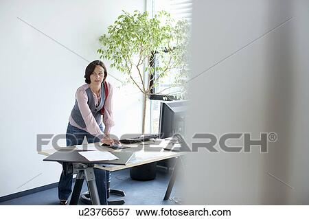 Stock Photo - Businesswoman using computer at desk. Fotosearch