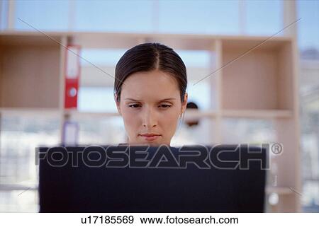 Stock Photo - Businesswoman using laptop in office. Fotosearch