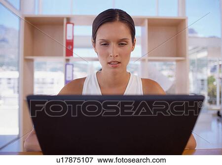 Stock Photo - Businesswoman using laptop in office. Fotosearch