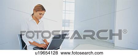 Businesswoman using laptop in office View Large Photo Image Stock Photo - Businesswoman using laptop in office. Fotosearch
