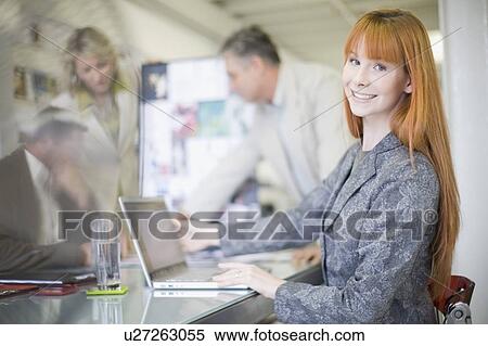 Stock Photography - Businesswoman using laptop in office. Fotosearch