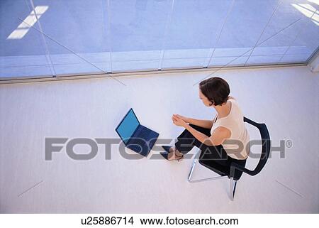 Businesswoman using laptop on floor View Large Photo Image Picture - Businesswoman using laptop on floor. Fotosearch